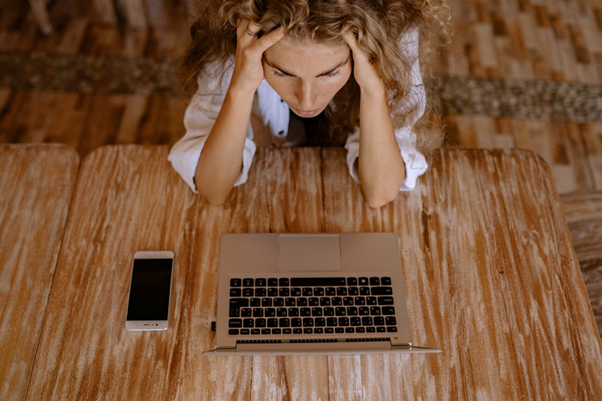 A girl is stressed while using Social Media on her laptop